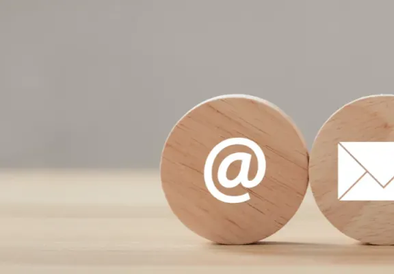 Drei hölzerne Kreise mit weißen Icons für Mail, Brief und Telefon